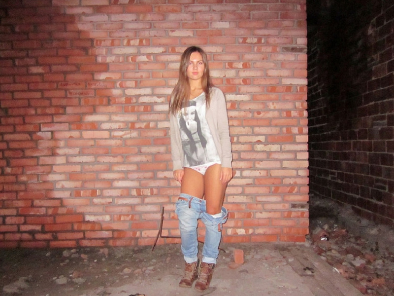 Молодая леди показывает стриптиз на фоне кирпичной стены 3 фото